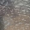 Zdjęcie zbliżenia na ciemniejszą część mozaikowego wzoru, gdzie drobne szaro-grafitowe kwadraty tworzą kontrastową płyta węglowa matowa w stylu serii metalowej