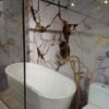Panele ścienne WPC NP24046 UHD w połysku z białym marmurem i złotymi żyłami w eleganckiej łazience z wanną wolnostojącą