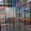 Czarna powierzchnia panelu z pionowymi, wielokolorowymi smugami światła, tworząca efektowną płyta węglowa czarna w połysku z serii metalowej.
